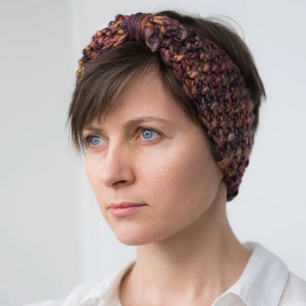 Beautiful young woman in knit headband — Stock Photo, Image