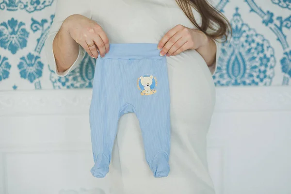 Donna incinta con i pantaloni del bambino — Foto Stock