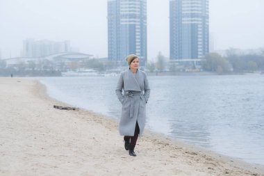 Gri paltolu genç bir kadın tek başına gidiyor.