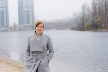 Gri paltolu genç bir kadın tek başına gidiyor.