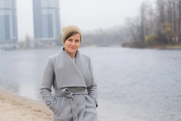 Giovane donna che se ne va da sola con un cappotto grigio — Foto Stock