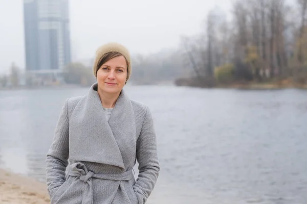 Junge Frau, die allein im grauen Mantel davonläuft — Stockfoto