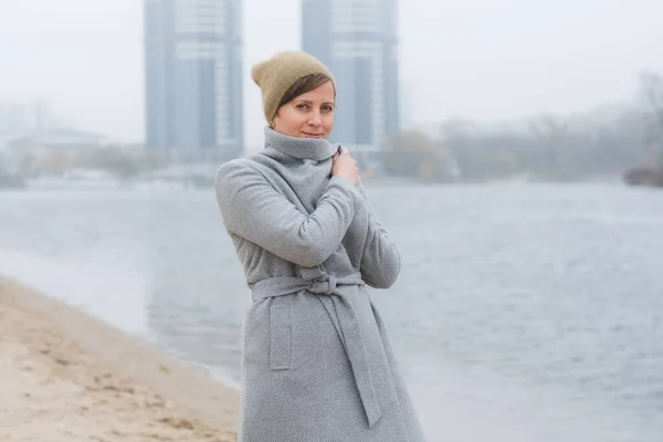 Mujer joven caminando sola usando un abrigo gris —  Fotos de Stock