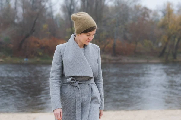 Ung kvinna gå iväg ensam bär en grå överrock — Stockfoto
