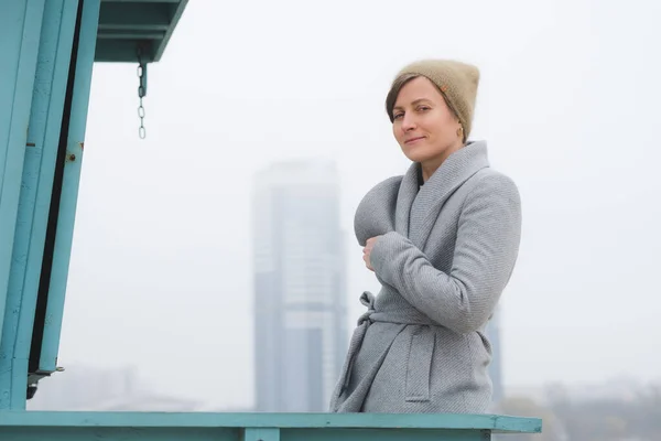 Giovane donna che se ne va da sola con un cappotto grigio — Foto Stock