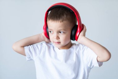 Küçük çocuk kulaklıkla müzik dinlemekten zevk alıyor.