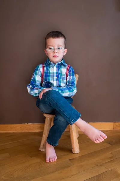 Mavi gömlek ve pantolon askısıyla gülümseyen yakışıklı bir çocuk. — Stok fotoğraf
