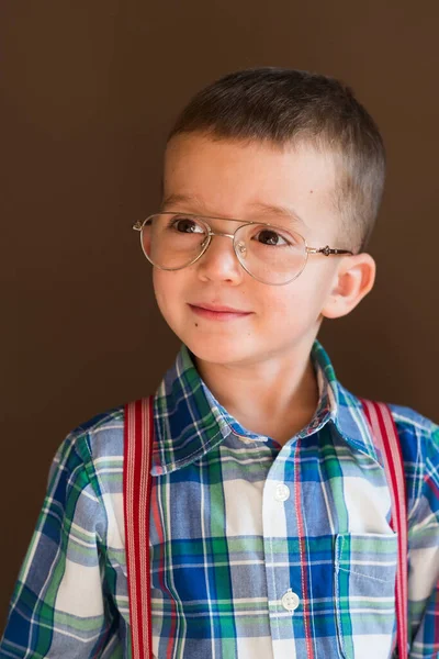 Smiling kid looking at camera in front of blackboard — Stock Photo, Image