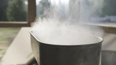 Sos tavasında yemek pişirirken buhar yükseliyor. Yemek yaparken buhar / buhar