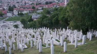 Bosna-Hersek 'in Saraevo kentindeki bir mezarlığın havadan görünüşü. Bölgedeki tepelerin manzarası. Yan görünüm için etrafında dönüyor.