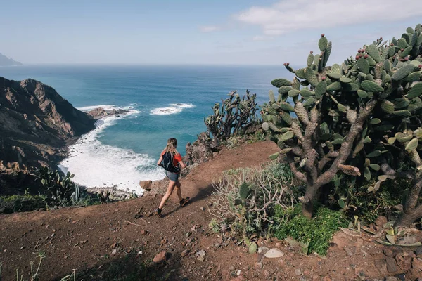 Una donna corre attraverso il paese su un sentiero in montagna a Canary Island. Vista sull'oceano — Foto Stock