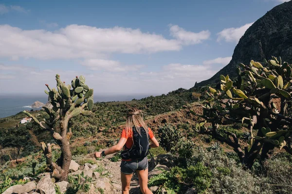 Mulher corre através do país em um caminho no caminho da montanha em Canary Island. Vista mar — Fotografia de Stock