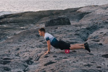 Adam kendi vücuduna rulo ile masaj yapıyor. Bağ eğitimi