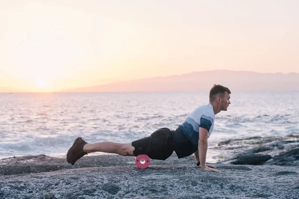 男人在靠近海洋的地方做身体的自我按摩 — 图库照片