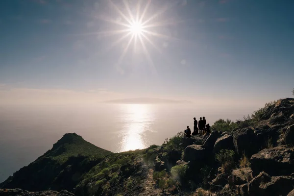 Junger glücklicher Tourist auf einem Berg und genießt Meerblick vor Sonnenuntergang — Stockfoto