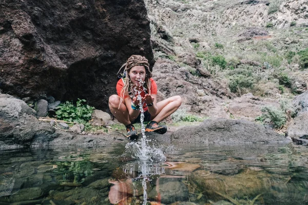 Jeune randonneuse femme boire de l'eau de ruisseau en montagne — Photo