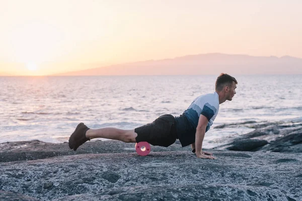 男人在靠近海洋的地方做身体的自我按摩 — 图库照片