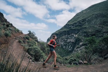 Dağ yolunda koşan kadın izleri. Koşucu güzel bir doğayla çalışıyor..