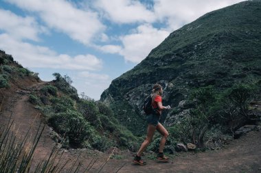 Genç fitness kadın patika koşucusu dağın tepesinde koşuyor
