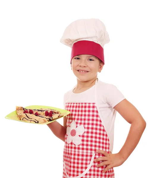 Feliz niña cocinero con crepes dulces en el plato —  Fotos de Stock