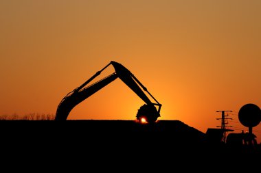 Ekskavatör inşaat site siluet üzerinde çalışma 