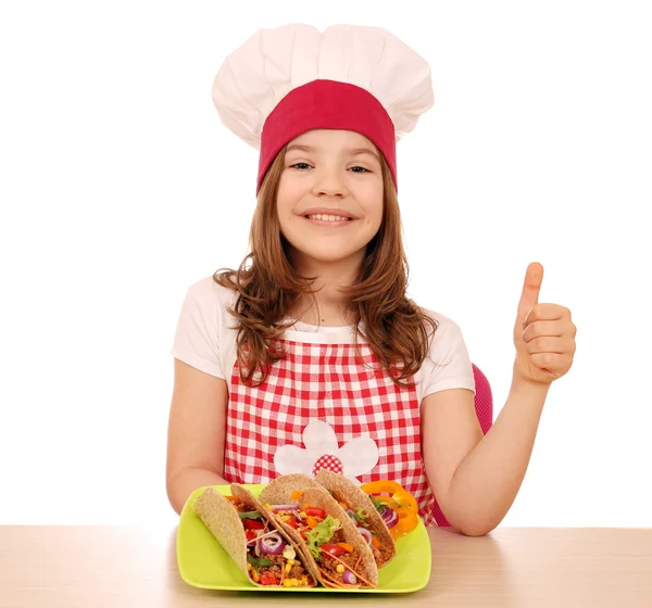 Happy little girl cook with tacos and thumb up — Stock Photo, Image