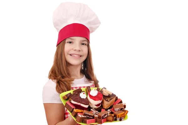 Heureuse petite fille cuisinier avec des gâteaux — Photo