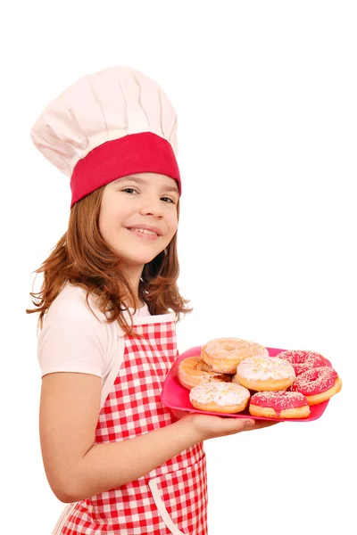 Glückliches kleines Mädchen kocht mit Donuts — Stockfoto