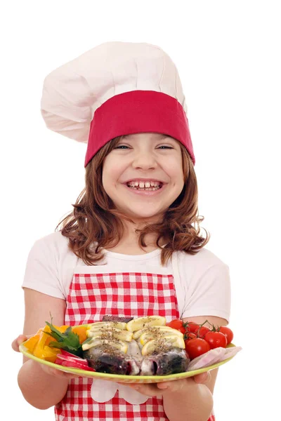 Щаслива маленька дівчинка готує з рибою форелі на тарілці — стокове фото
