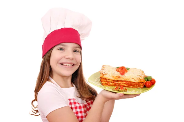 Happy little girl cook with tasty lasagne on plate — Stock Photo, Image