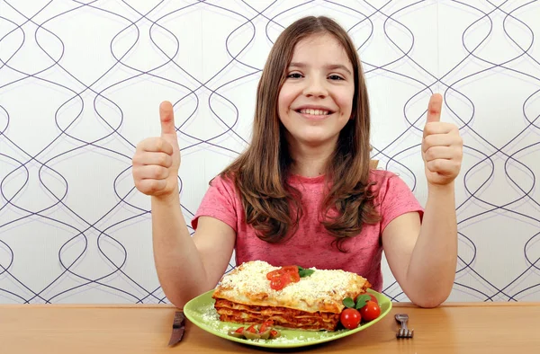 Glückliches kleines Mädchen mit Lasagne und Daumen hoch — Stockfoto