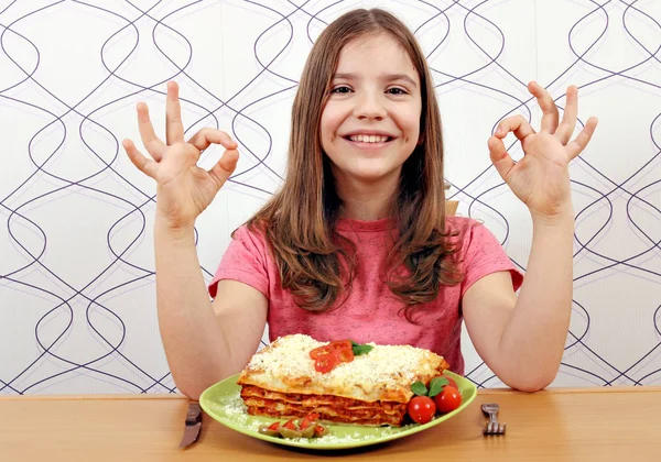 Šťastná holčička s lasagne a značka ok ruky — Stock fotografie
