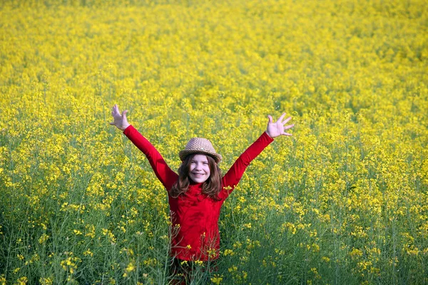 Meisje met handen omhoog op veld voorjaar seizoen — Stockfoto