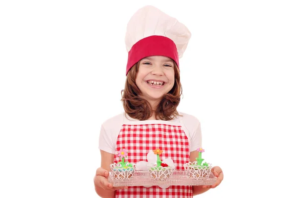 Happy little girl cook with decorated muffin — Stock Photo, Image