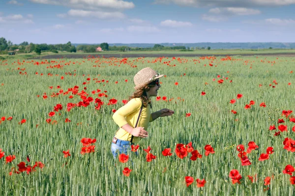 Heureuse petite fille court à travers un champ de blé vert — Photo