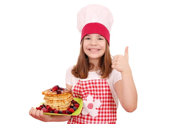 Menina feliz cozinhar com panquecas e polegar para cima — Fotografia de Stock