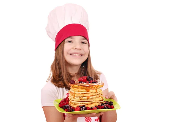 Feliz niña cocinera con tortitas en el plato —  Fotos de Stock