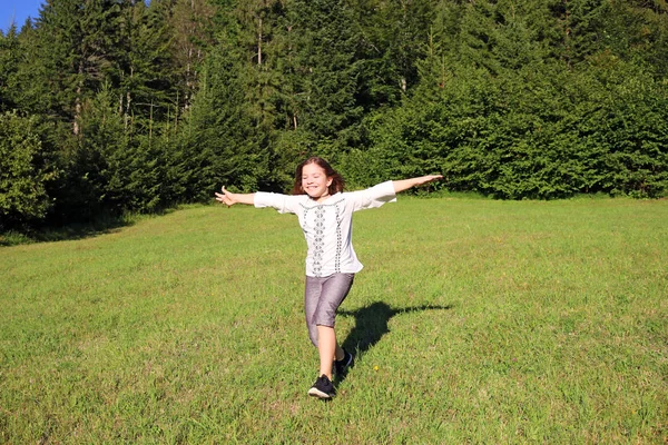 Happy little girl running on green field — Stock Photo, Image