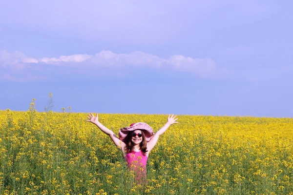 Dziewczynka z ręce do góry na pole wiosną sezonu — Zdjęcie stockowe
