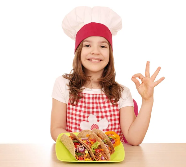 Felice bambina cuoca con tacos e ok segno della mano — Foto Stock