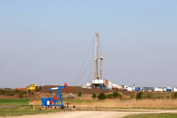 Oljefält med pump jack och olja borrigg — Stockfoto