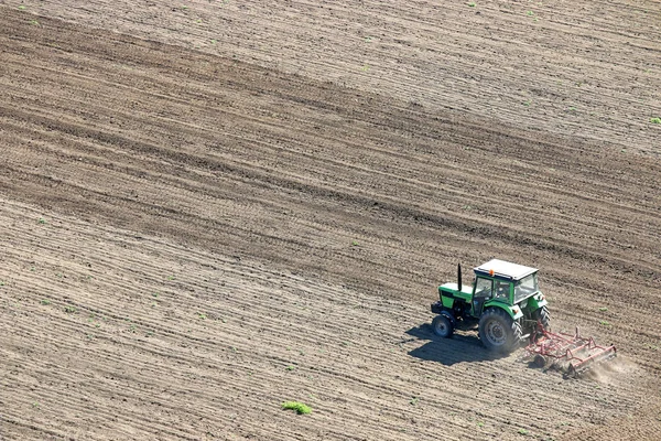 Tractor plowing a field aerial view — Stock Photo, Image