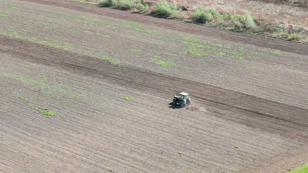 Трактор, вспахивающий поле зрения с воздуха — стоковое видео