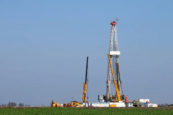 Land oil drilling rig and machinery on field — Stock Photo, Image