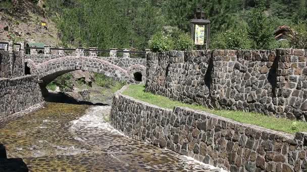 Pequeño puente de piedra en la montaña — Vídeo de stock