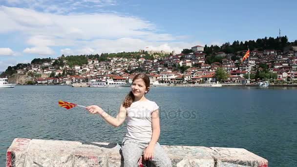 Bambina ondeggia con una bandiera macedone sul lago Ohrid — Video Stock