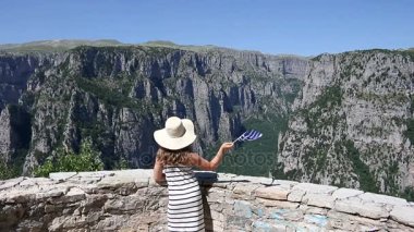 küçük kız dalgalar Vikos bir Yunan bayrağı ile Zagoria geçit