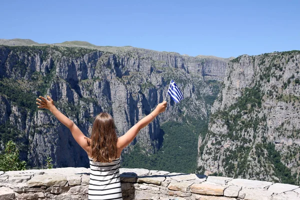 Ondas menina pequena com uma bandeira grega no desfiladeiro Vikos Zagoria Greec — Fotografia de Stock