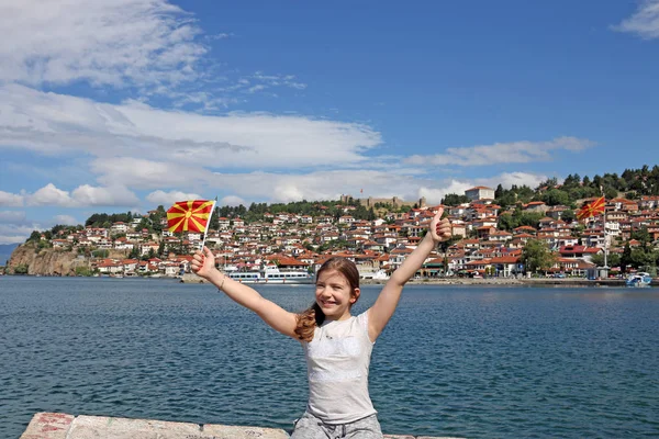 Malá dívka vlny s makedonská vlajka na Ohridské jezero — Stock fotografie