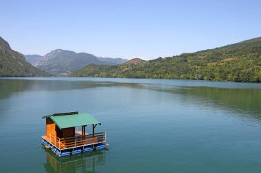 wooden house floating on Drina river Serbia clipart